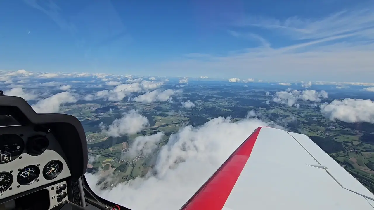 Blick aus dem Cockpit eines Sportflugzeugs über der Wolkendecke